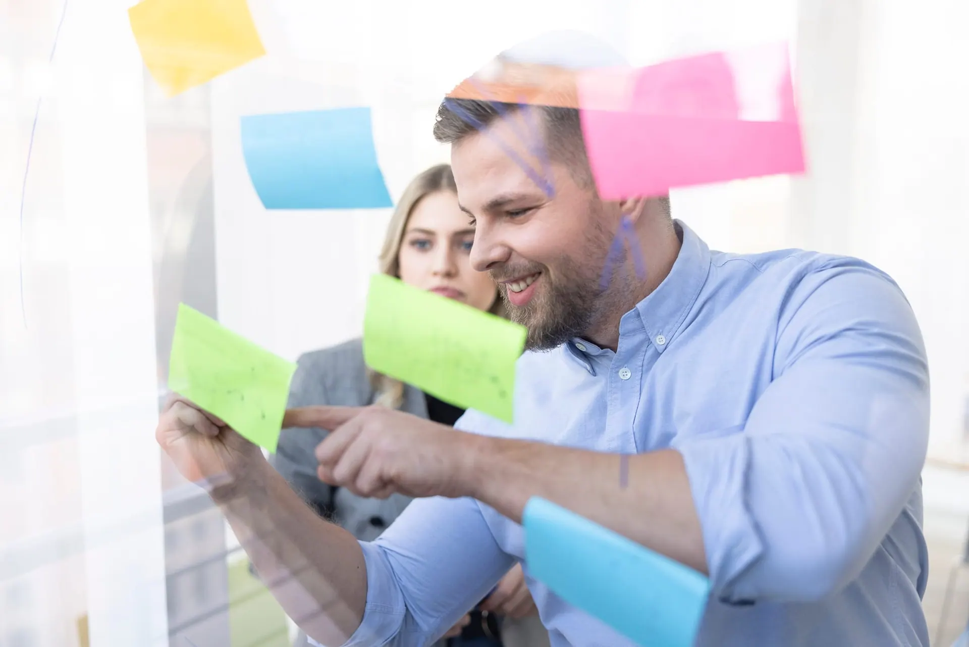 Workshop-Szene hinter einer mit Haftnotizen beklebten Glaswand