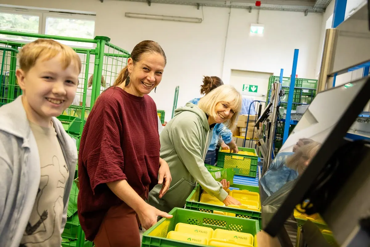 Drei Helferinnen mit Transportkisten