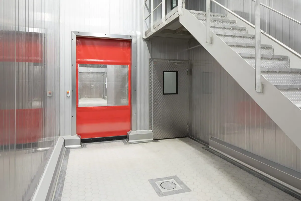 Roter Schnelllauftor am Ende eines weißen Korridors