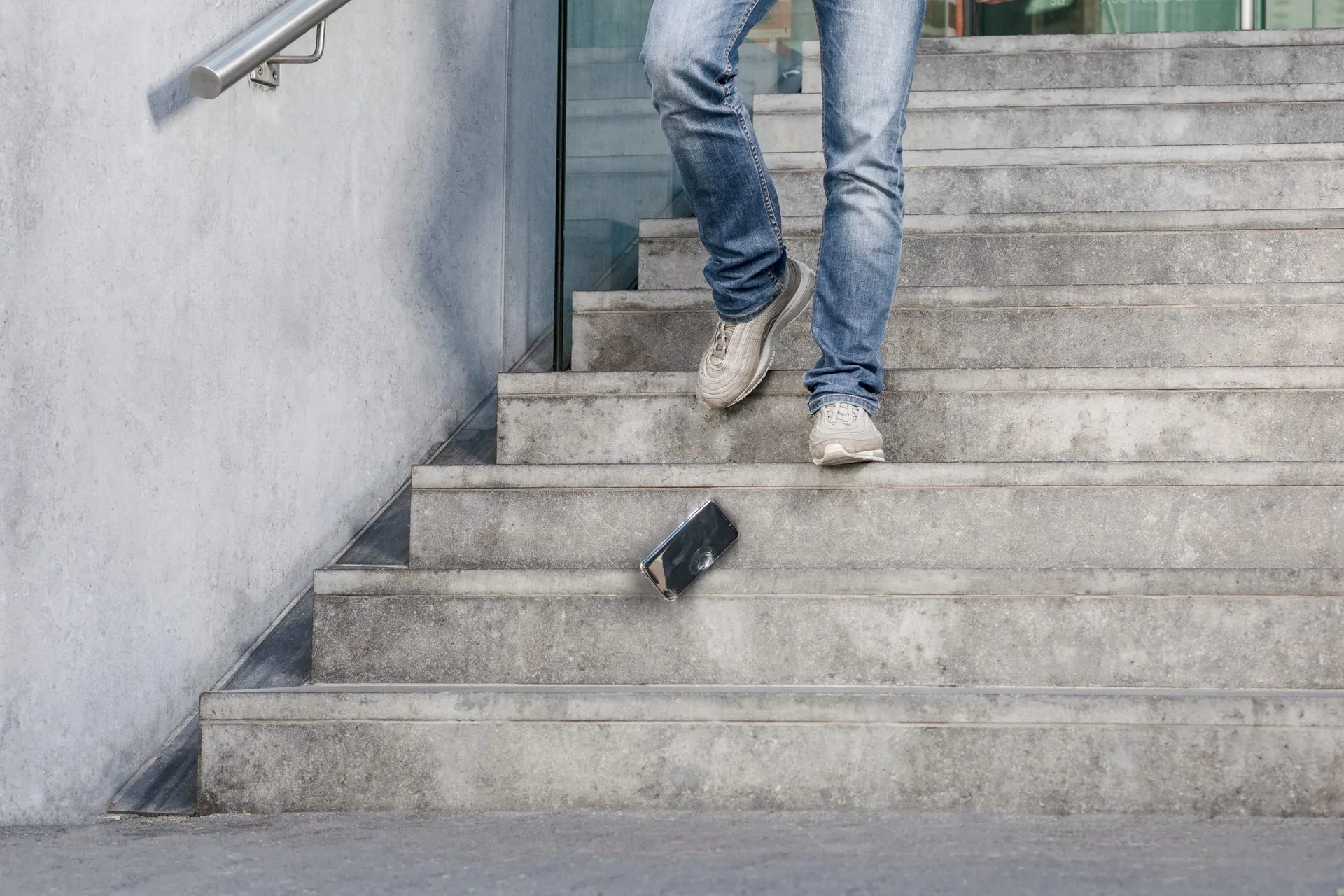 Smartphone fällt auf eine Steintreppe