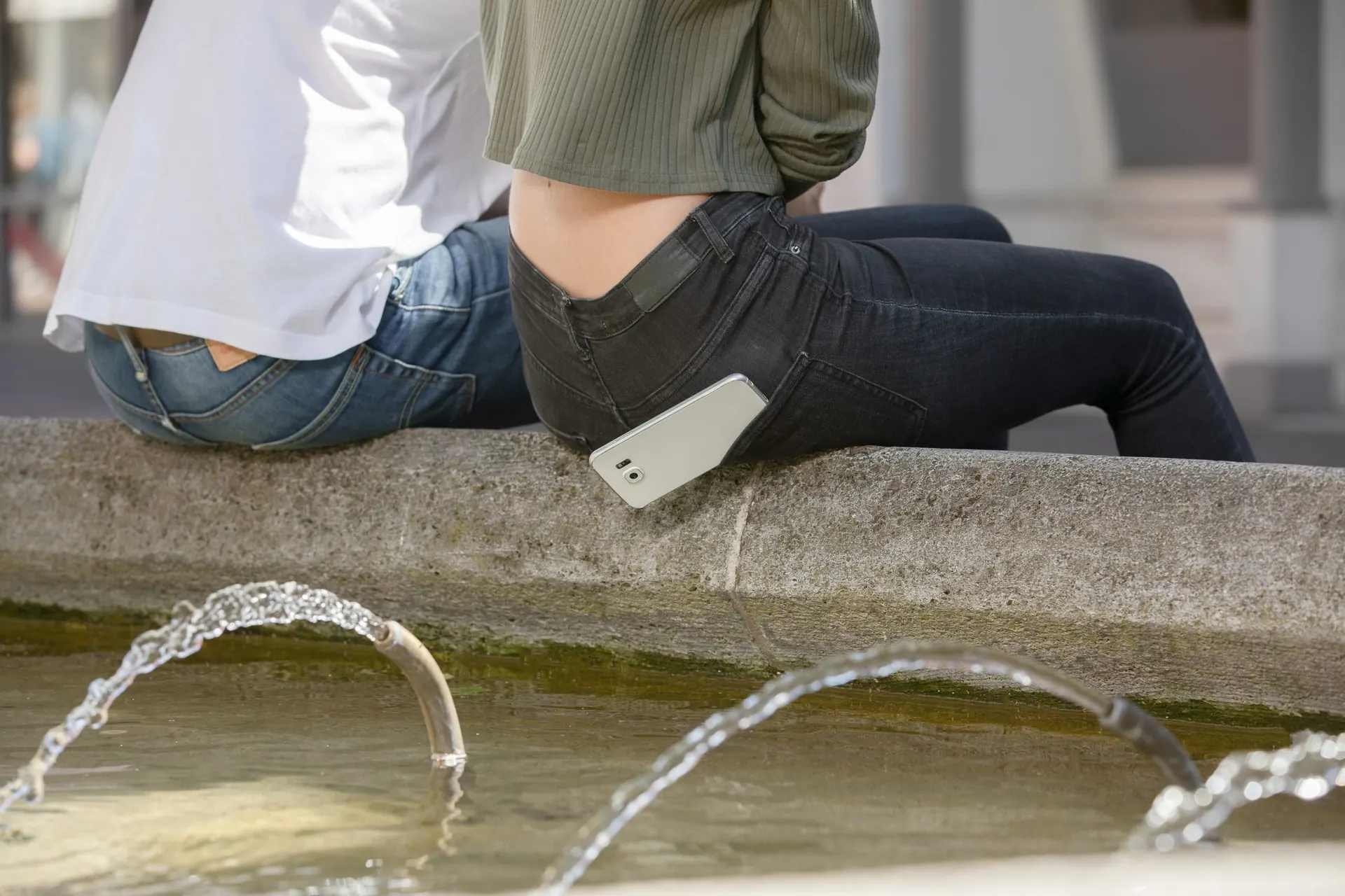 Smartphone liegt in einer Pfütze auf dem Gehweg